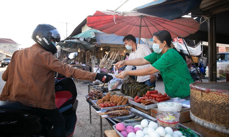 Vendors wearing masks sell take-away food in Vientiane, Laos, June 19, 2021. Laos has extended its lockdown COVID-19 prevention measures across the country for a further 15 days as the community spread of COVID-19 in the capital continues. (Photo: Xinhua)