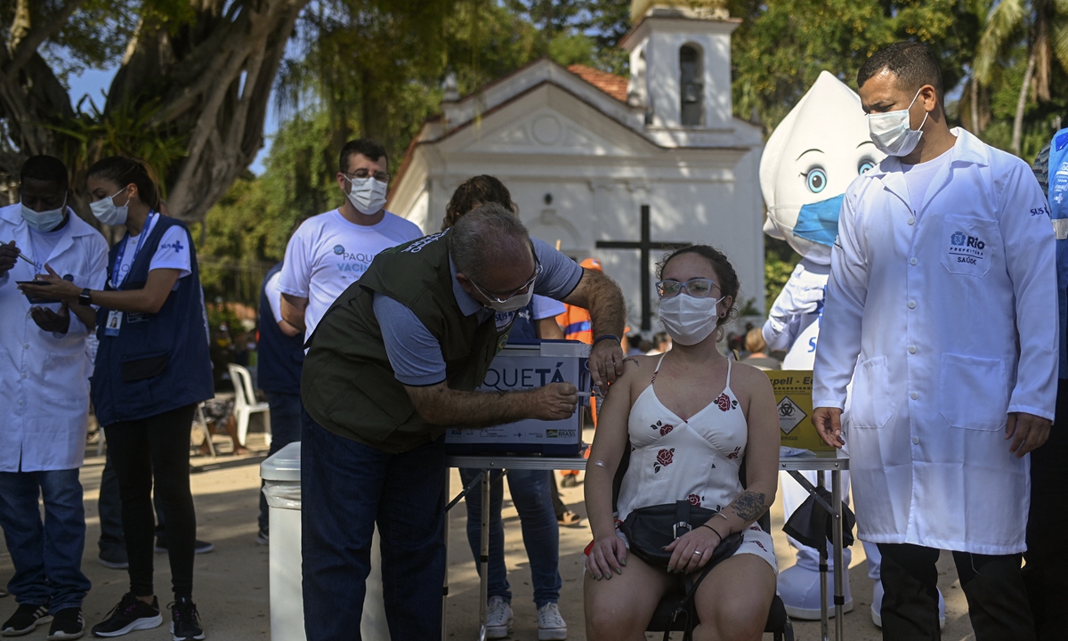 Brazil's Health Minister Marcelo Queiroga gives a dose of AstraZeneca vaccine against COVID-19 during the first day of a mass vaccination campaign within the 'Paqueta Vaccinated' project, at Paqueta island in Rio de Janeiro, Brazil on Sunday. Photo: AFP