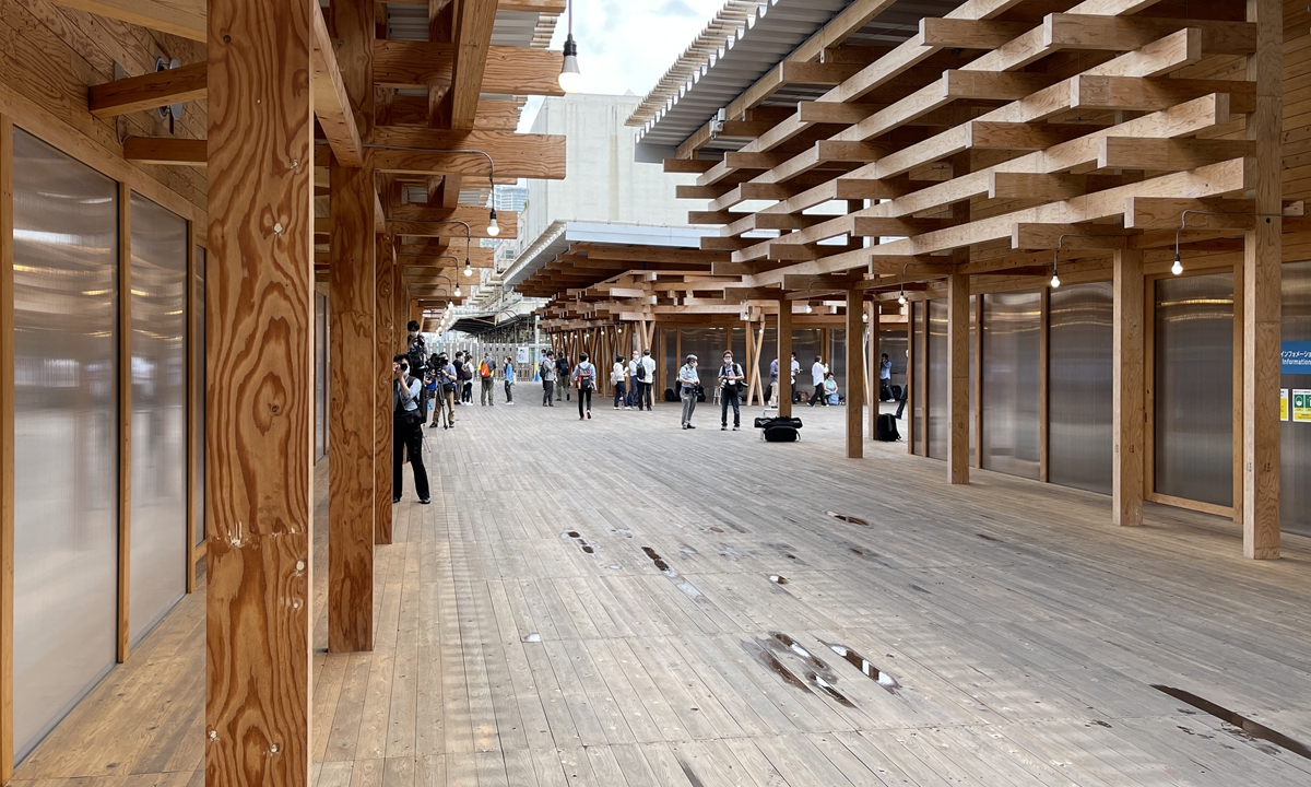 People walk through the Tokyo 2020 Olympic Village on Monday. The village was built using 40,000 types of wood from different places in Japan, with each type marked with its origin. The wood will be recycled to build public facilities after the games. Photo: AFP