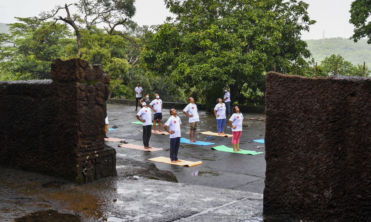 People take part in a yoga session at the Kanheri Caves on the outskirts of Mumbai on Monday to mark the International Yoga Day. Over a dozen cities and regions in India eased lockdown restrictions on Monday. Photo: AFP
