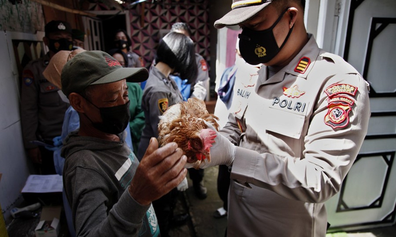 A man receives a live chicken from a police officer after he gets a dose of the COVID-19 vaccine at Cianjur district, West Java, Indonesia. June 22, 2021.(Photo: Xinhua)