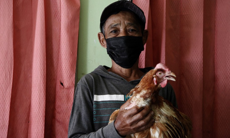 A man holds a live chicken after he gets a dose of the COVID-19 vaccine at Cianjur district, West Java, Indonesia. June 22, 2021.(Photo: Xinhua)
