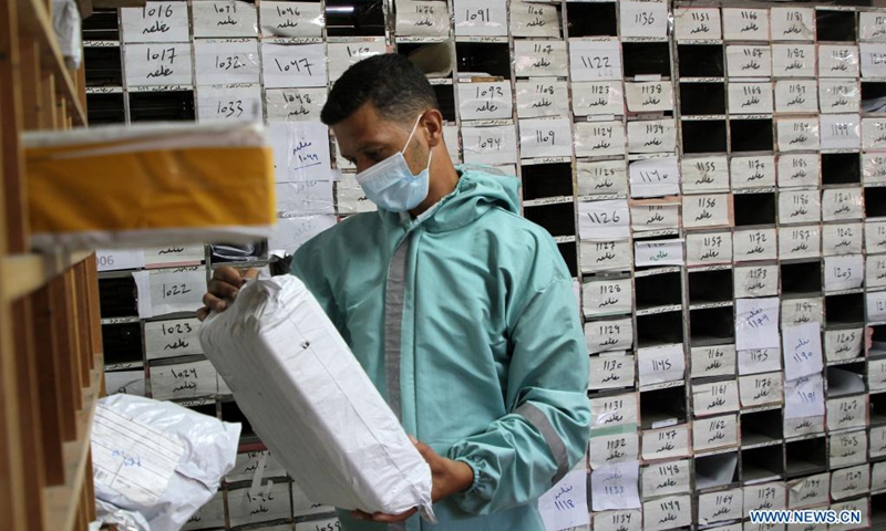 A Palestinian man works at the main Gaza Post Office in Gaza City, on June 22, 2021. For the second day in a row, dozens of trucks loaded with agricultural goods and clothes arrived at the Kerem Shalom commercial crossing in the southern Gaza Strip. These goods from Gaza were allowed to be exported to the West Bank and Israel.(Photo: Xinhua)