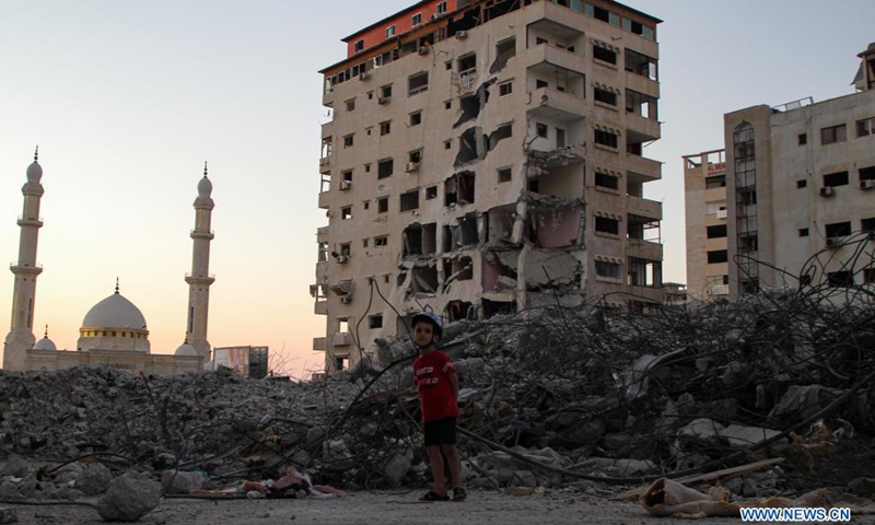 A Palestinian boy stands near the rubble of a building destroyed by Israeli air strikes in Gaza City, on June 21, 2021.(Photo: Xinhua)