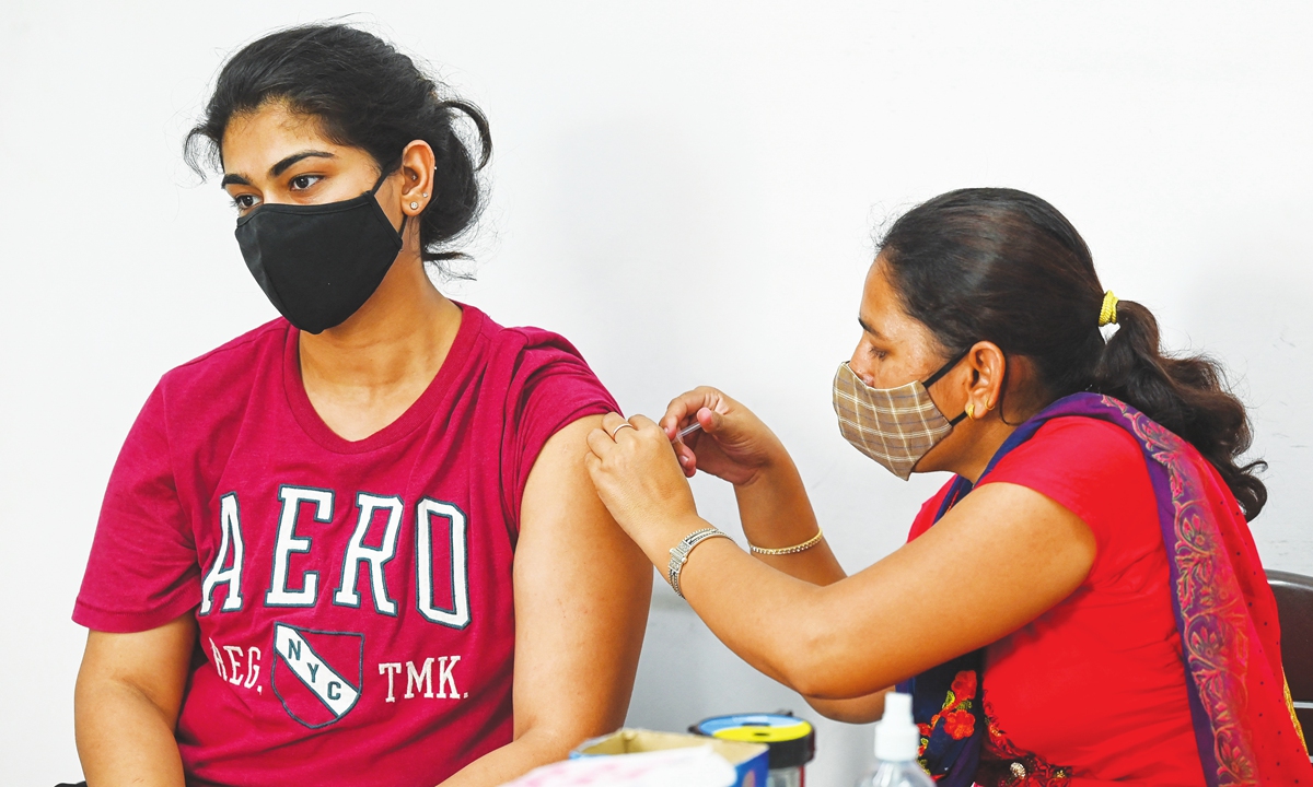 A health worker inoculates a woman with a dose of the Covishield vaccine against the COVID-19 coronavirus at a vaccination center for international travelers, in New Delhi on Tuesday. Photo: AFP
