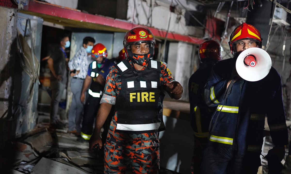 Firefighters inspect the scene after a suspected gas explosion at Moghbazar area in Dhaka on Sunday. At least seven people were killed and 50 were injured so far as three-storied building in Moghbazar area in Bangladesh's capital Dhaka collapsed partially in a suspected gas explosion. Photo: VCG