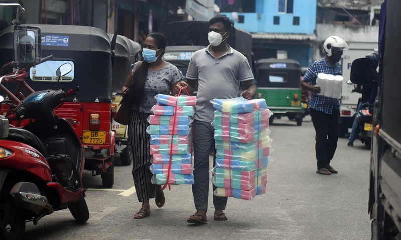 People carry goods at a market in Colombo, Sri Lanka, on June 21, 2021.(Photo: Xinhua)