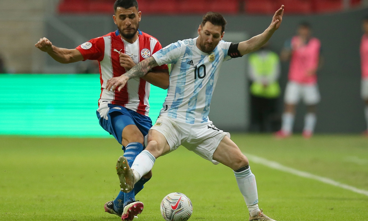 Junior Alonso (left) of Paraguay competes for the ball with Lionel Messi of Argentina on Monday in Brasilia, Brazil. Photo: VCG