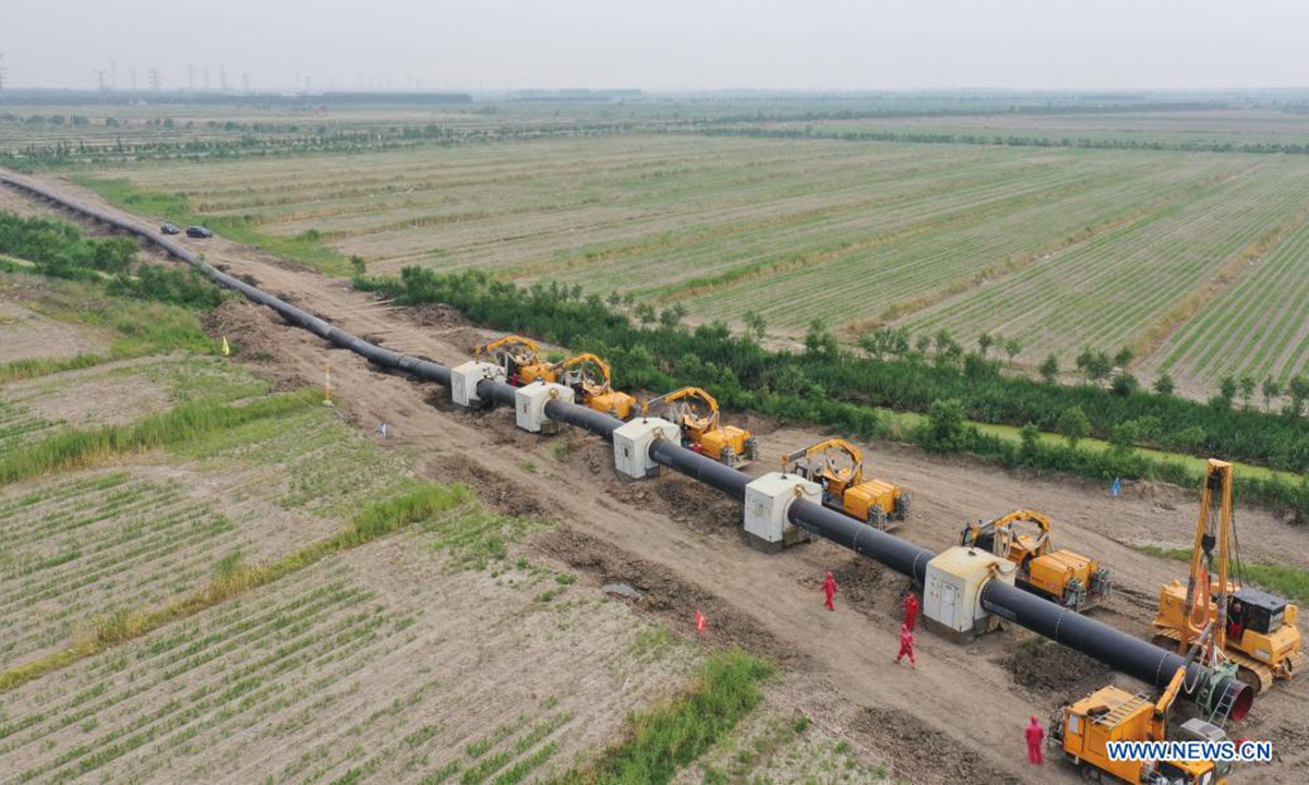 Aerial photo taken on June 24, 2021 shows workers installing pipe sections at a construction site for the outbound pipeline of a liquefied natural gas (LNG) receiving station, in Wanglanzhuang Township, Fengnan District, Tangshan City of north China's Hebei Province. This 176.18-kilometer pipeline, when finished, is expected to duct natural gas from the Xintian LNG receiving station in Caofeidian District of Tangshan to Baodi District of Tianjin, also in north China. (Xinhua/Yang Shiyao)