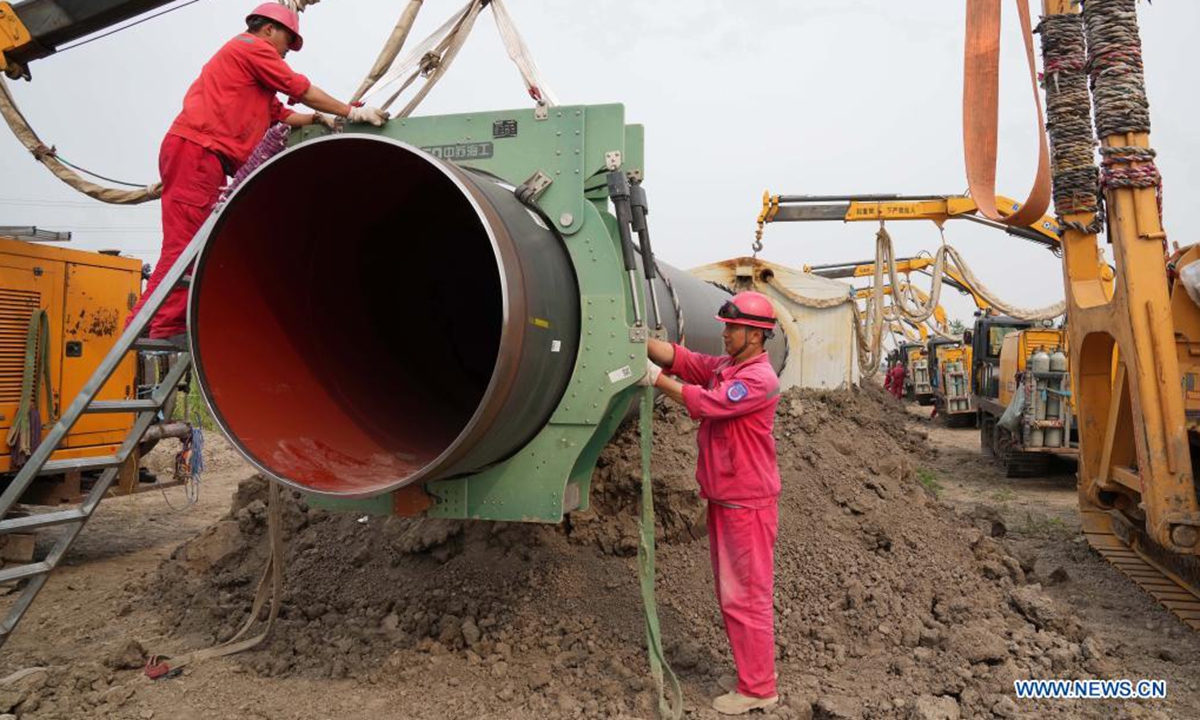Aerial photo taken on June 24, 2021 shows workers installing pipe sections at a construction site for the outbound pipeline of a liquefied natural gas (LNG) receiving station, in Wanglanzhuang Township, Fengnan District, Tangshan City of north China's Hebei Province. This 176.18-kilometer pipeline, when finished, is expected to duct natural gas from the Xintian LNG receiving station in Caofeidian District of Tangshan to Baodi District of Tianjin, also in north China. (Xinhua/Yang Shiyao)
