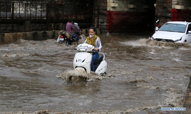 Vehicles run on a road flooded due to heavy rainfall in Bhopal, capital of India's Madhya Pradesh state, June 22, 2021. (Str/Xinhua)