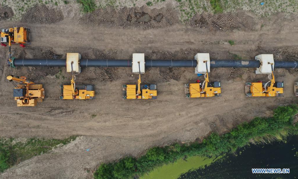 Aerial photo taken on June 24, 2021 shows workers installing pipe sections at a construction site for the outbound pipeline of a liquefied natural gas (LNG) receiving station, in Wanglanzhuang Township, Fengnan District, Tangshan City of north China's Hebei Province. This 176.18-kilometer pipeline, when finished, is expected to duct natural gas from the Xintian LNG receiving station in Caofeidian District of Tangshan to Baodi District of Tianjin, also in north China. (Xinhua/Yang Shiyao)