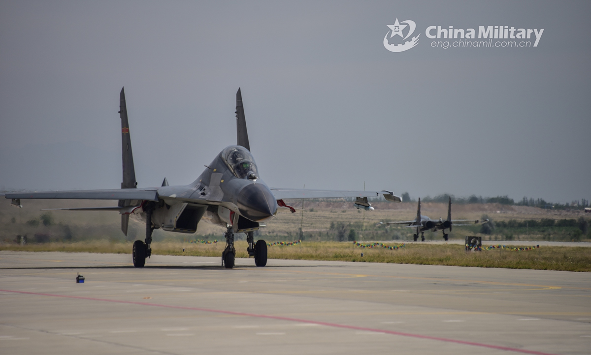 Two fighter jets attached to an aviation brigade of the air force under the PLA Western Theater Command taxi on the flightline in sequence under control tower’s command during a flight training exercise on June 10, 2021. (eng.chinamil.com.cn/Photo by Cao Yukun)