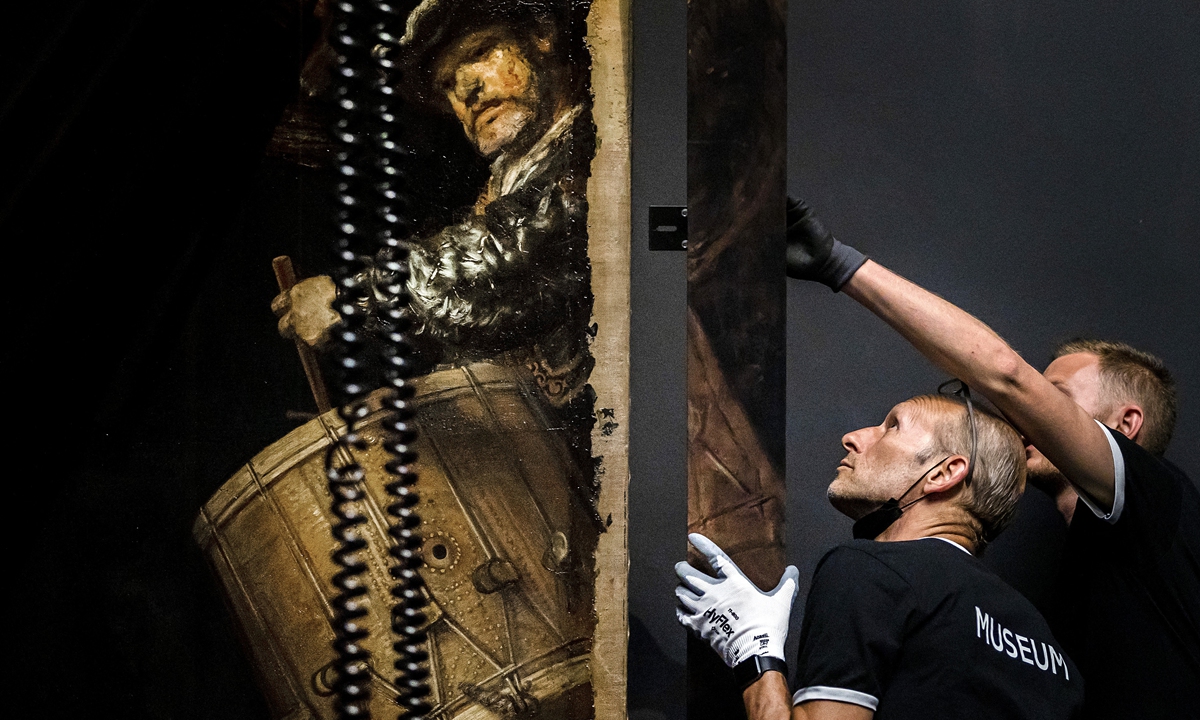 Workers add a painted frame to <em>The Night Watch</em> at the Rijksmuseum Museum during Operation Night Watch, the largest ever investigation into the painting by Dutch master Rembrandt, in Amsterdam on Tuesday. Photos: AFP