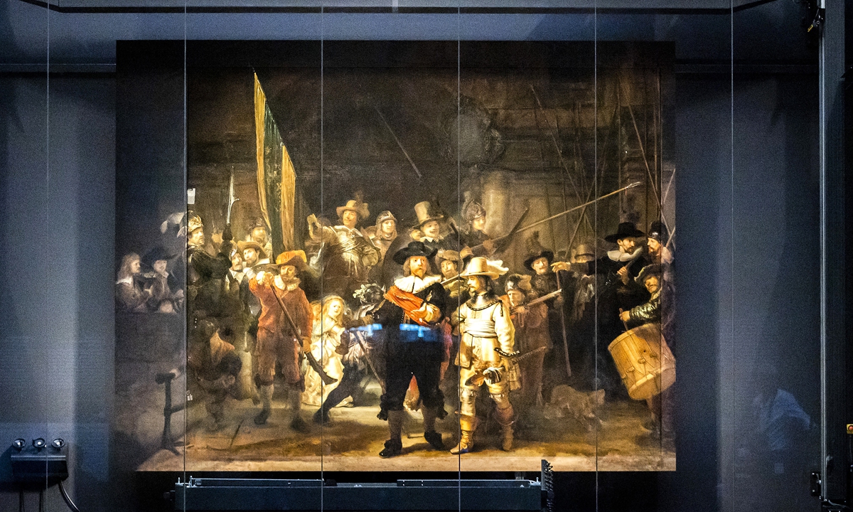 Workers add a painted frame to <em>The Night Watch</em> at the Rijksmuseum Museum during Operation Night Watch, the largest ever investigation into the painting by Dutch master Rembrandt, in Amsterdam on Tuesday. Photos: AFP