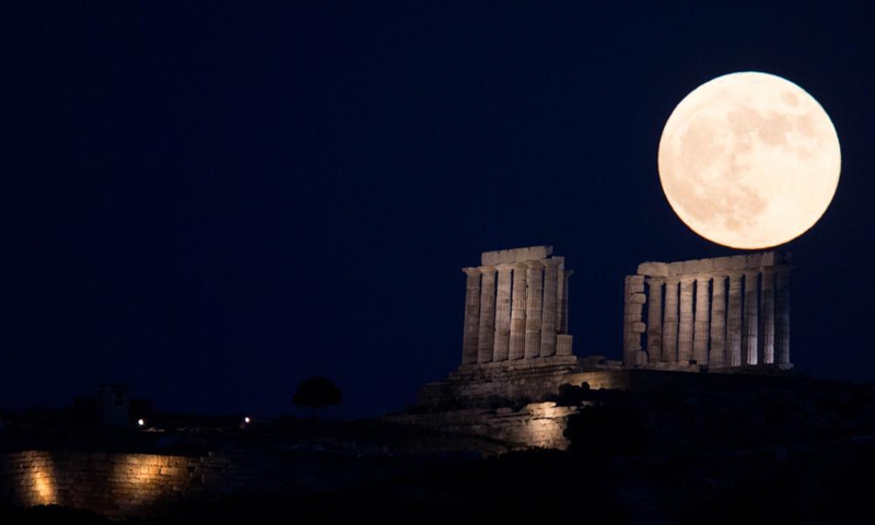 The full moon is seen rising over the Temple of Poseidon at cape Sounion, some 70 km southeast of Athens, Greece, on June 24, 2021.Photo:Xinhua