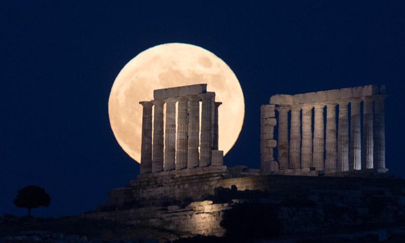 The full moon is seen rising over the Temple of Poseidon at cape Sounion, some 70 km southeast of Athens, Greece, on June 24, 2021.Photo:Xinhua