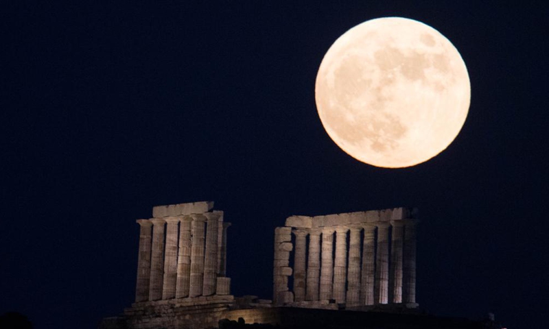 The full moon is seen rising over the Temple of Poseidon at cape Sounion, some 70 km southeast of Athens, Greece, on June 24, 2021.Photo:Xinhua