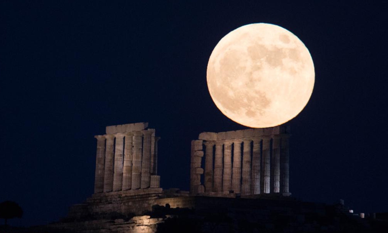 The full moon is seen rising over the Temple of Poseidon at cape Sounion, some 70 km southeast of Athens, Greece, on June 24, 2021.Photo:Xinhua