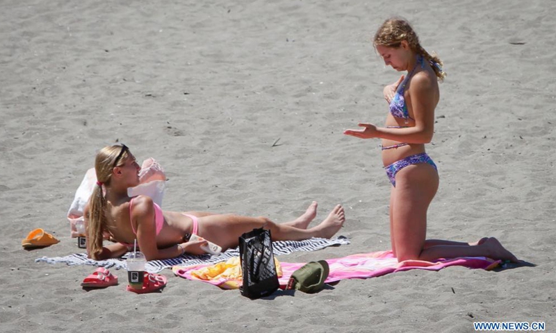 People enjoy themselves at a beach under the heat wave warning at English Bay in Vancouver, British Columbia, Canada, June 24, 2021.Photo:Xinhua