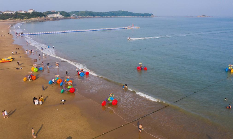 Aerial photo taken on June 24, 2021 shows tourists enjoy seaside time at the Nansha beach resort on Zhujiajian Island, Zhoushan, east China's Zhejiang Province.Photo:Xinhua