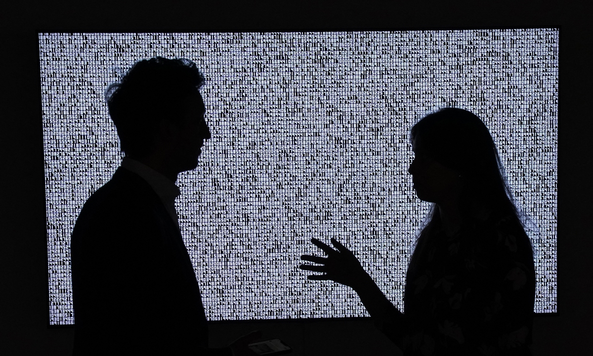 A woman looks at an NFT artwork by Mad Dog Jones titled <em>SHIFT/</em> on June 10 in New York.
Top: An NFT artwork by Ryoji Ikeda titled <em>A Single Number That Has 10,000,086 Digits</em>  Photos: AFP