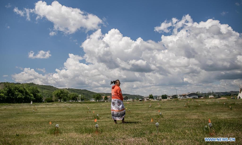 A member of the Cowessess First Nation stands at the site of unmarked graves near a former indigenous residential school in Saskatchewan, Canada, on June 27, 2021. The Cowessess First Nation, an indigenous group in Saskatchewan, on Thursday announced a preliminary discovery of 751 unmarked graves near a former indigenous residential school.(Photo: Xinhua)