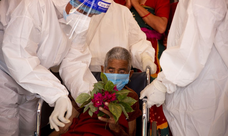 Health workers congratulate 92-year-old Kalika Devi Baskota in a wheelchair in an isolation ward in Kathmandu, Nepal on June 25, 2021.(Photo: Xinhua)