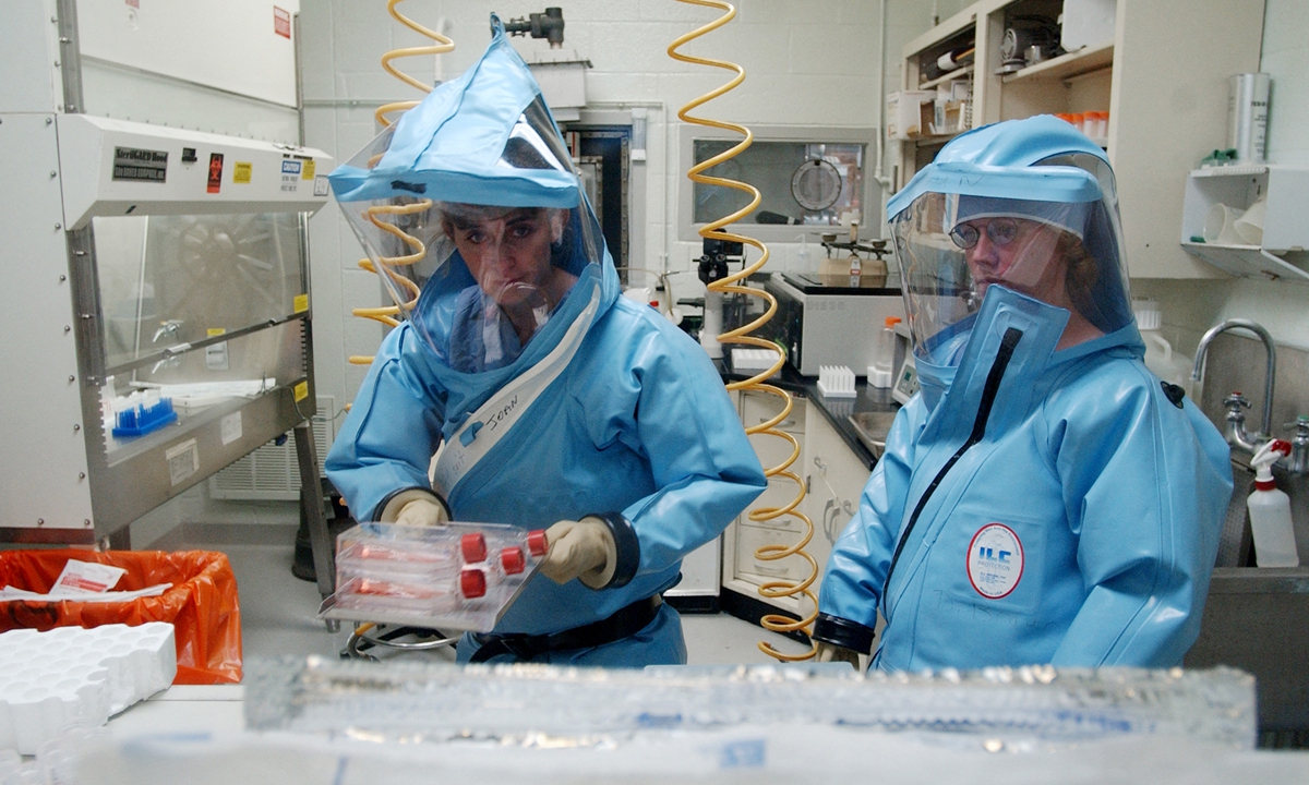 Research personnel work inside the bio-level 4 lab at the USAMRIID at Fort Detrick on September 26, 2002.
Photo: AFP