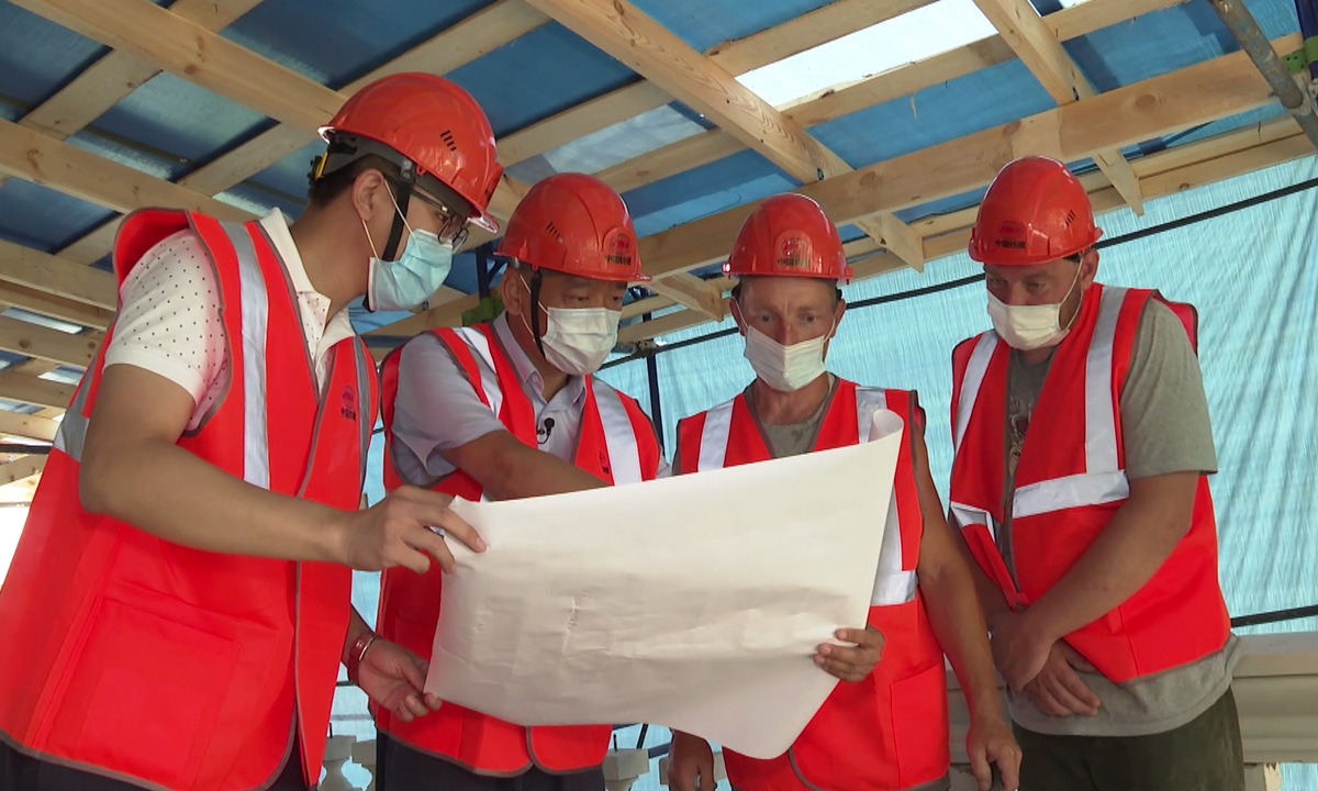 Engineers examine a blueprint of the exhibition hall on the site of the 6th National Congress of the CPC in Moscow. Photo: Courtesy of China Railway Construction Corp 