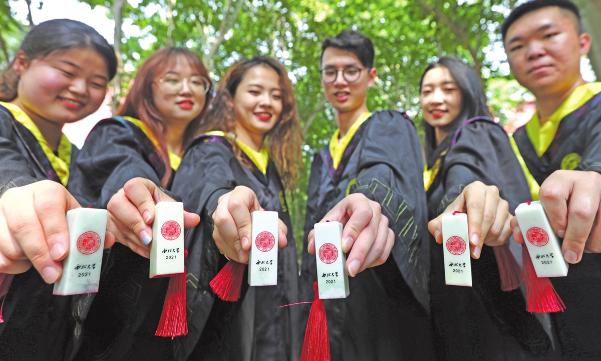 Graduates of a university in Xi'an, Northwest China's Shaanxi Province, show Lantian jade seals engraved with their names that the school gives as gifts. Photo: IC