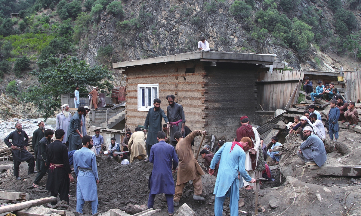 Local people search for victims of  a mudslide following heavy flooding in Nuristan, east of Kabul, Afghanistan, on Saturday. Flash flooding killed over 100 people in a remote area controlled by the Taliban. Photo: VCG