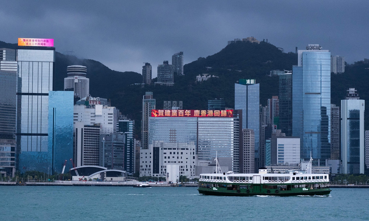 A ferry passes through an LED board displaying a slogan celebrating the 100th anniversary of the founding of the CPC and the 24th anniversary of Hong Kong's return to the motherland in Hong Kong. Photo: VCG