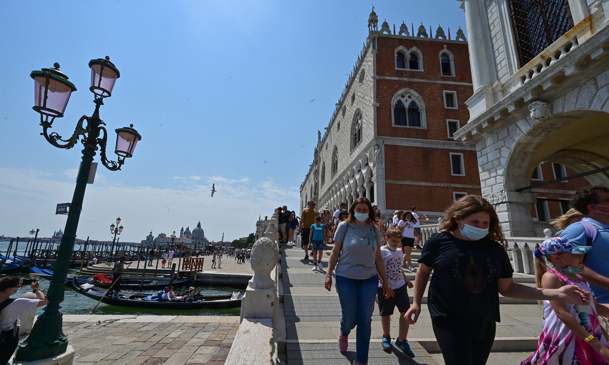 Tourists stroll across the Ponte della Paglia bridge in Venice, Italy on June 5. Photo: AFP