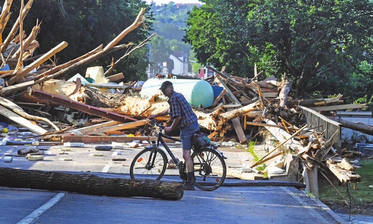 A man on a bicycle is seen on a destroyed bridge in Bad Neuenahr-Ahrweiler, western Germany, on Saturday. Devastating floods in Germany and other parts of western Europe have been described as a 