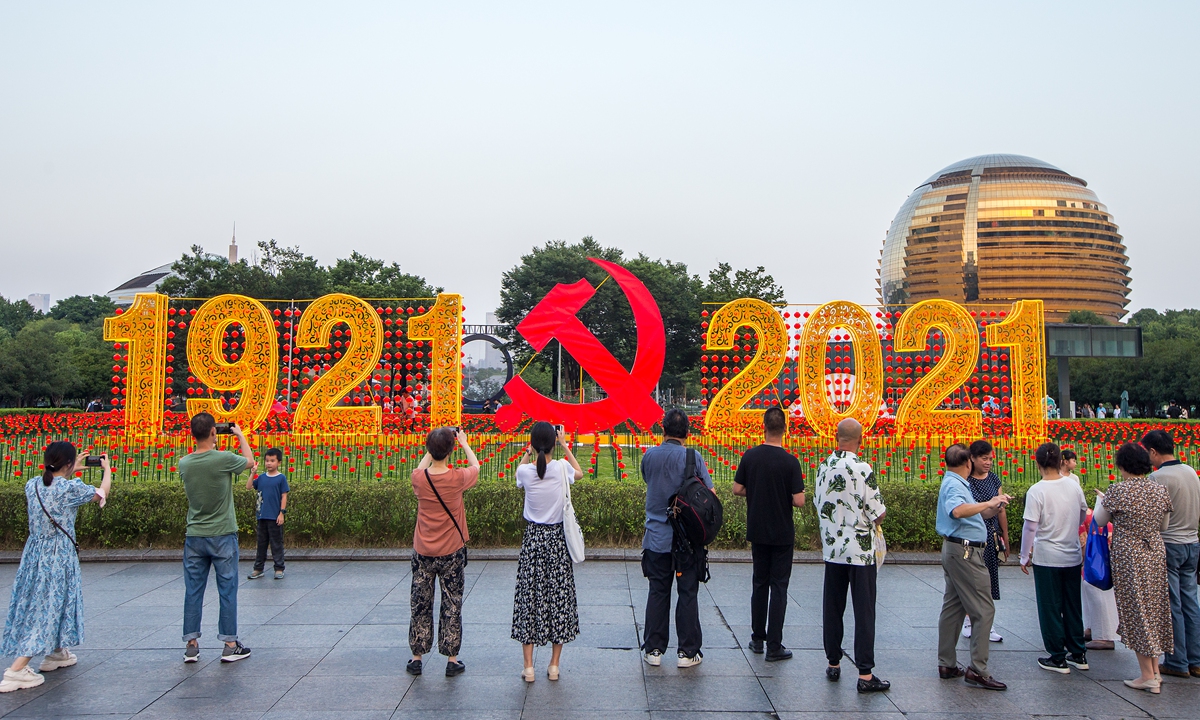 People take photos in front of a display celebrating the 100th anniversary of the founding of the Communist Party of China on Monday in Hangzhou, Zhejiang Province. Photo: VCG