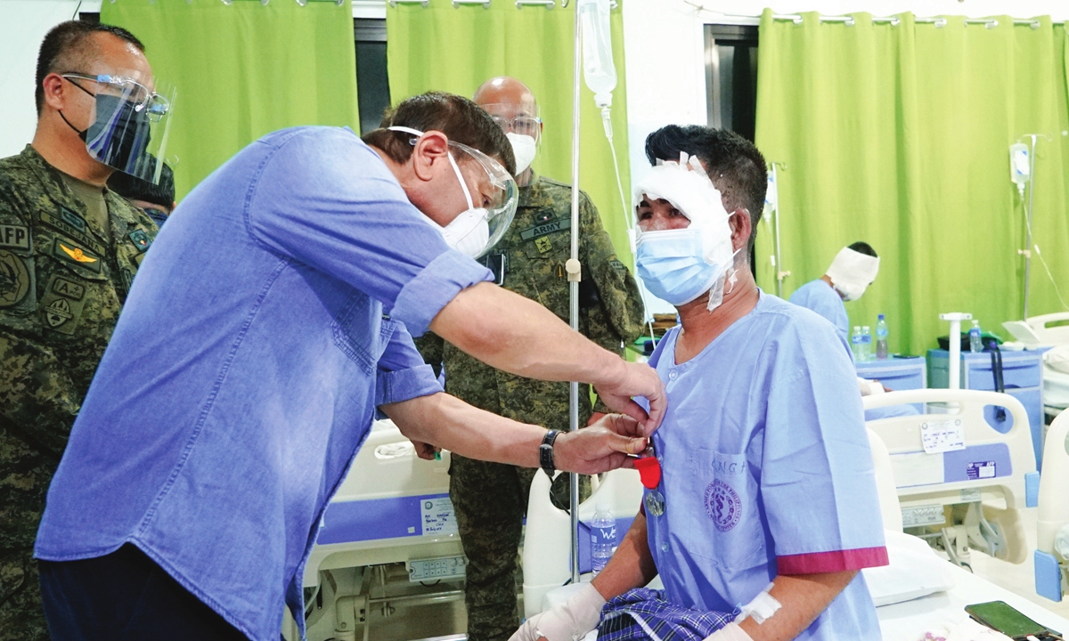 In this handout photo, Philippine president Rodrigo Duterte confers the Order of Lapu-Lapu with the Rank of Kampilan to one of the wounded soldiers who survived during the C-130 plane crash in Sulu province during his visit at Camp Navarro General Hospital, Western Mindanao Command in Zamboanga City, southern Philippines on Monday. Photo: VCG
