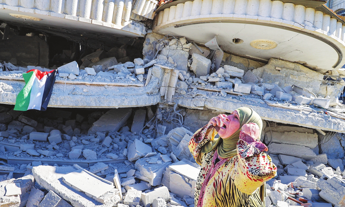 A Palestinian woman reacts outside a building that belonged to Montasser Shalabi, who was arrested in May on suspicion of carrying out a drive-by shooting attack on an Israeli student, after it was demolished by Israeli forces in the village of Turmus'ayya near Ramallah in the occupied West Bank on Thursday. Photo: AFP