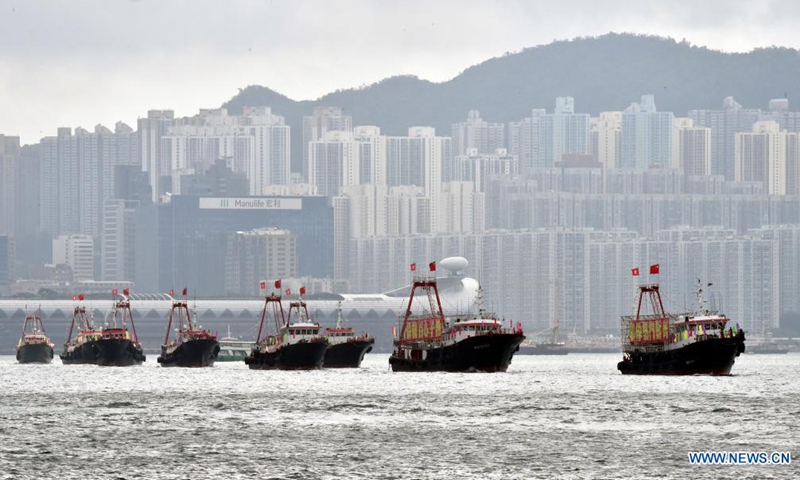 Fishing boats flying China's national flags and the flags of the Hong Kong Special Administrative Region (HKSAR) cruise at Victoria Harbour in Hong Kong, south China, July 1, 2021.Photo:Xinhua