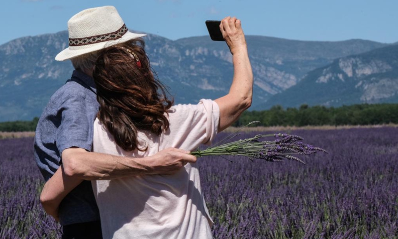 People take selfies among lavender blossoms on the Valensole plateau in Valensole, southern France, July 1, 2021.Photo:Xinhua