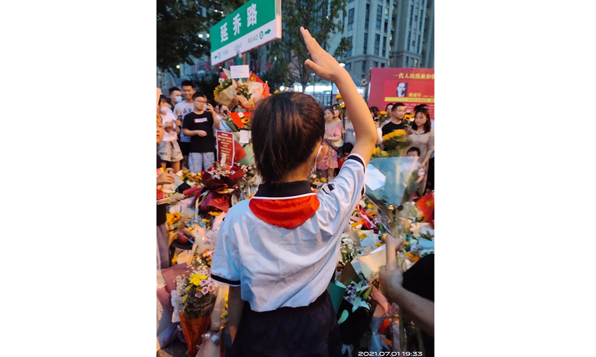 A Young Pioneer wearing a red scarf salutes the Yanqiao Road sign in Hefei, East China's Anhui Province on the Party's centennial. Photo: Zeng Hui