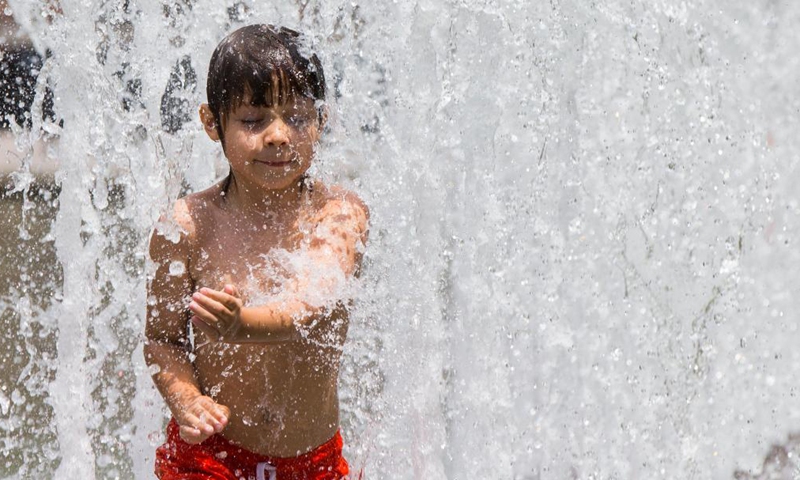 Children cool off in a fountain as hot and humid weather continues in Toronto, Canada, on July 1, 2021.Photo:Xinhua