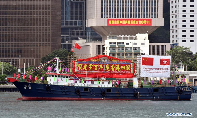 A fishing boat flying China's national flag and the flag of the Hong Kong Special Administrative Region (HKSAR) cruises at Victoria Harbour in Hong Kong, south China, July 1, 2021.Photo:Xinhua