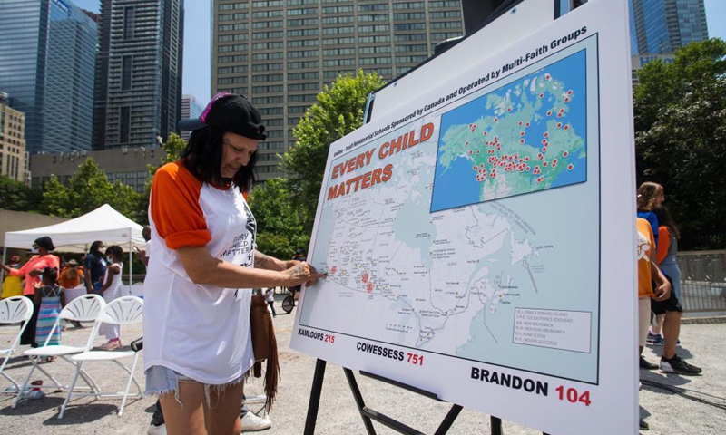 A woman looks at a map showing locations of indigenous residential schools during a rally in Toronto, Canada, on July 1, 2021. Hundreds of people gathered here on Thursday to pay tribute to indigenous children whose bodies were found in mass graves near former indigenous residential schools in Canada.Photo:Xinhua