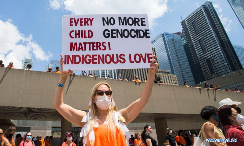 A woman holds a placard during a rally in Toronto, Canada, on July 1, 2021. Hundreds of people gathered here on Thursday to pay tribute to indigenous children whose bodies were found in mass graves near former indigenous residential schools in Canada.Photo:Xinhua