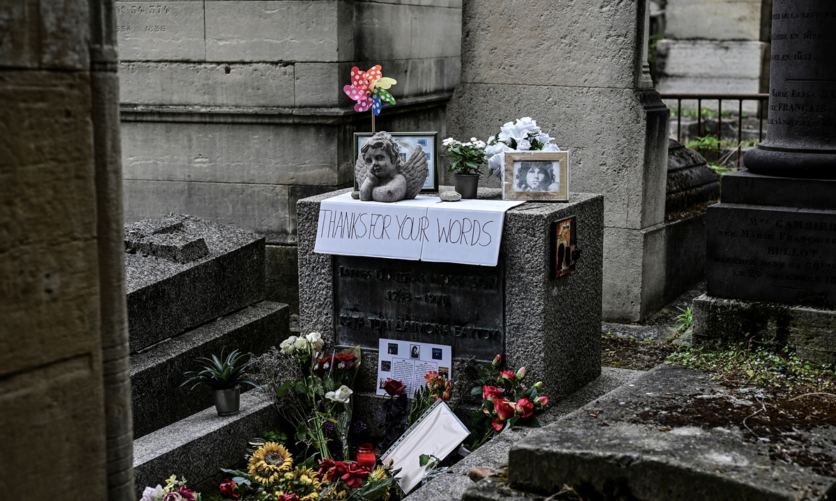 People gather by the grave of The Doors frontman Jim Morrison to commemorate the 50th anniversary of his death at the Pere Lachaise cemetery in Paris on Saturday. Photos: AFP