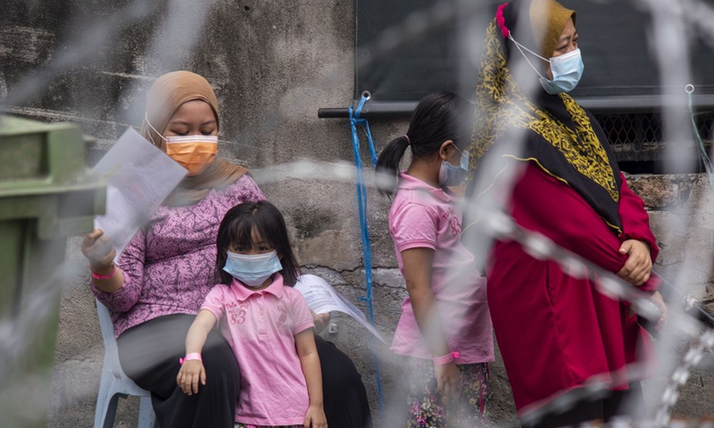 People wearing face masks wait for swab tests at an area subject to more restrictive movement control measures to curb COVID-19 in Kuala Lumpur, Malaysia, July 3, 2021.(Photo: Xinhua)