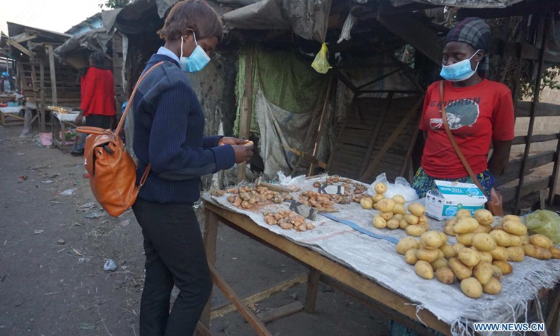 Naomi Kakoma (R), a 27-year-old trader at Lupili market, sells fresh ginger in Lusaka, Zambia, on June 27, 2021. Interactions with Lusaka-based traders revealed that spices with medicinal elements sales have more than doubled during the COVID-19 period and sellers are continuously running out of stock.(Photo: Xinhua)