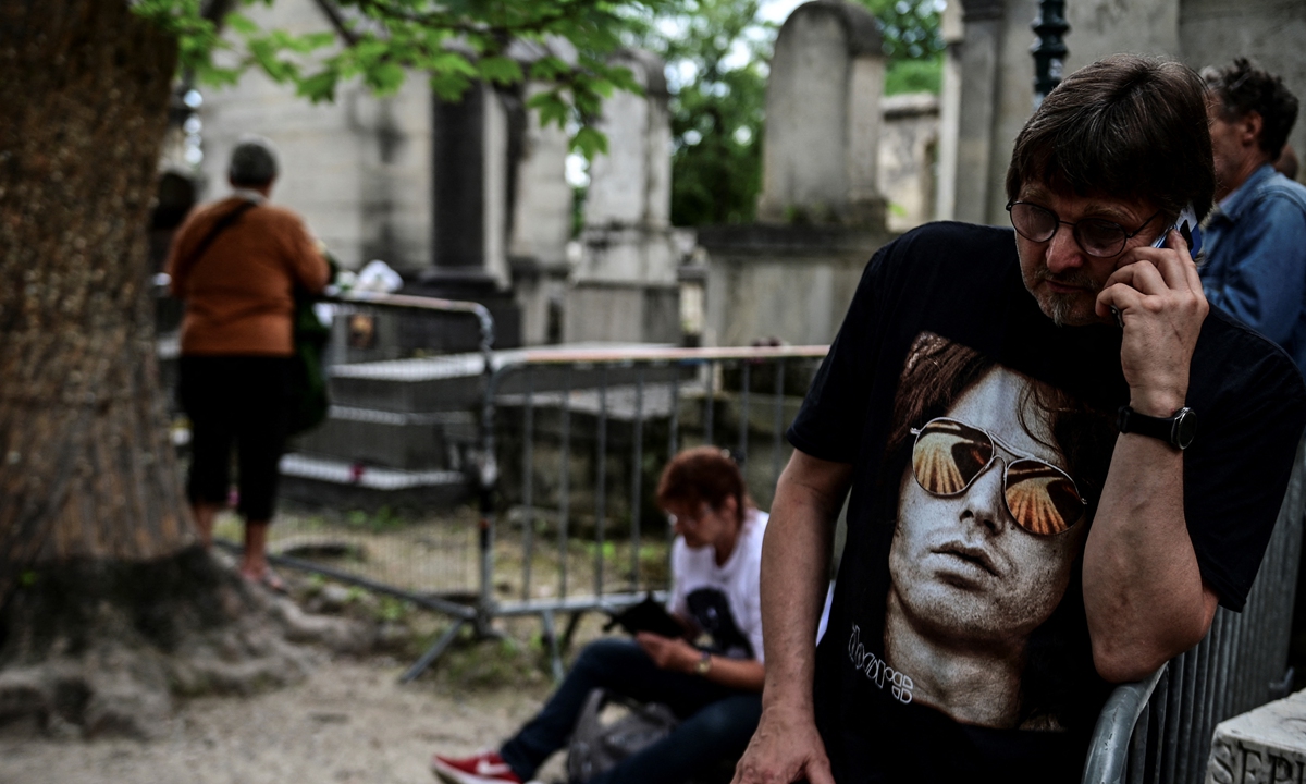 People gather by the grave of The Doors frontman Jim Morrison to commemorate the 50th anniversary of his death at the Pere Lachaise cemetery in Paris on Saturday. Photos: AFP