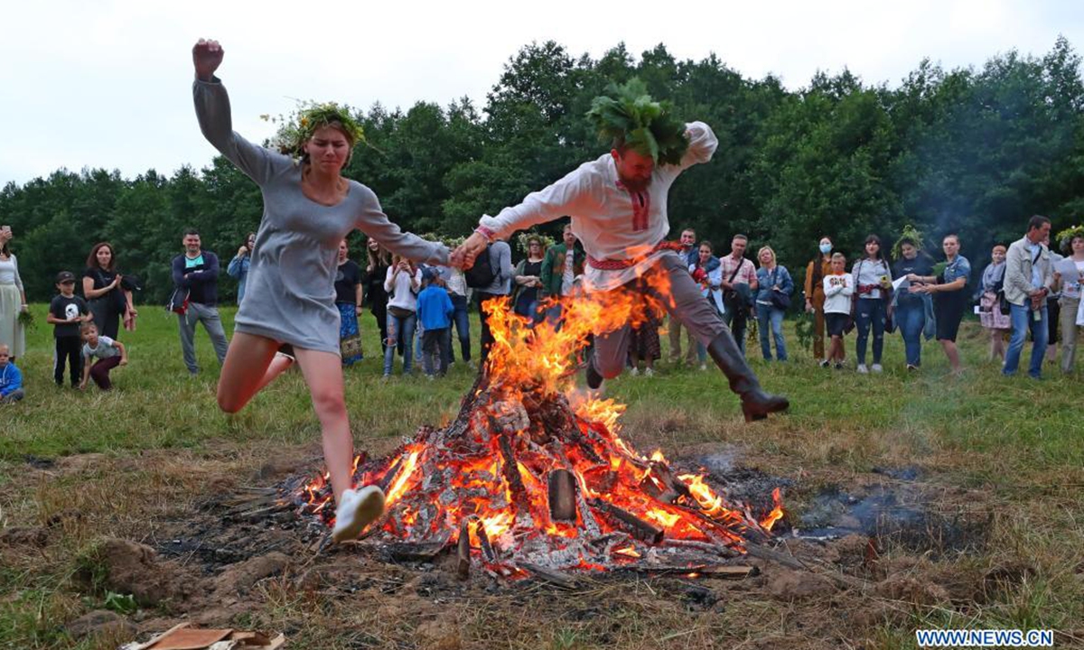 People jump over a bonfire during the celebrations of the Ivan Kupala Festival in the suburb of Minsk, Belarus, July 3, 2021. (Photo by Henadz Zhinkov/Xinhua) 
